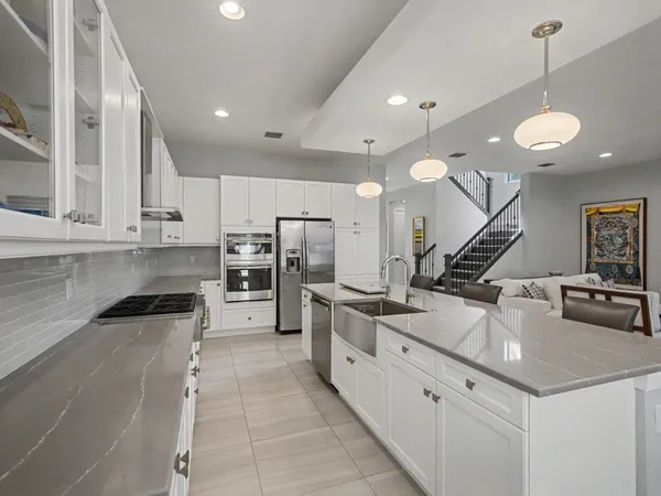 a kitchen with stainless steel appliances granite countertop a sink a stove and a refrigerator