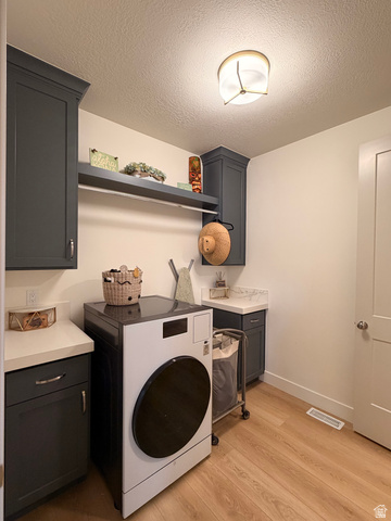 3626 Riverstone Road Mapleton, UT 84664 - Photo 34 of 58 Laundry area with washer / dryer, light wood-type flooring, a textured ceiling, and cabinet space