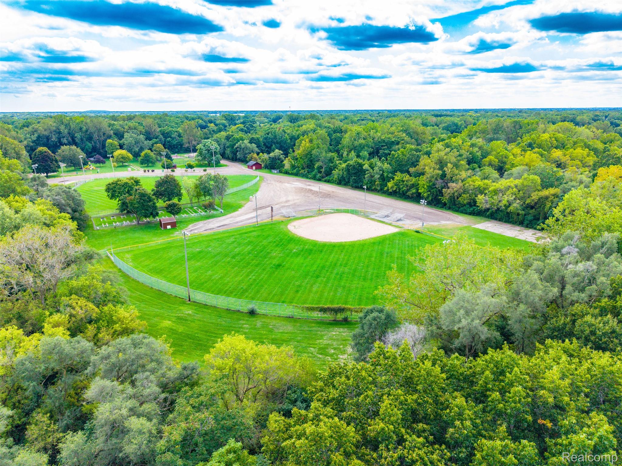 36739 Wick Road Romulus, MI 48174 - Photo 50 of 56 Expansive green space featuring a manicured lawn, baseball field, and surrounding mature trees