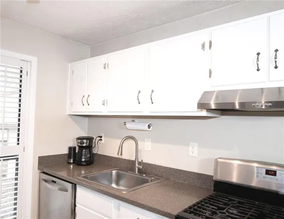 a kitchen with stainless steel appliances granite countertop a sink and a stove