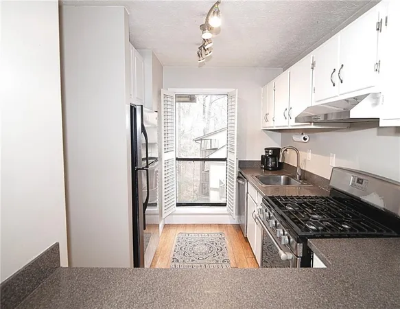a kitchen with stainless steel appliances granite countertop a stove and a refrigerator