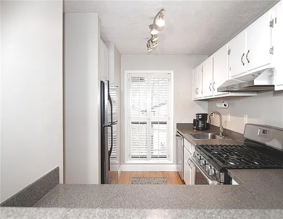 a kitchen with granite countertop a stove and a refrigerator