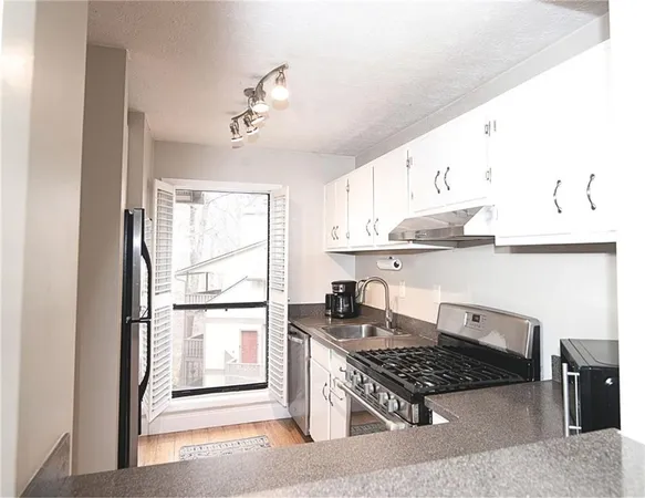 a kitchen with white cabinets and appliances