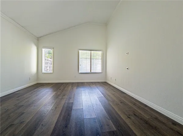 an empty room with wooden floor and window