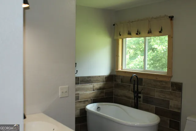 a bathroom with a toilet a sink and a window