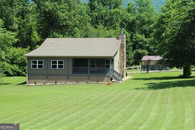 a front view of a house with a garden and trees