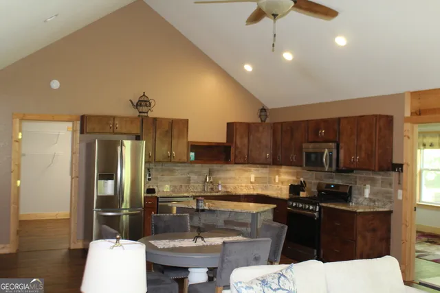 a kitchen with stainless steel appliances kitchen island granite countertop a sink and cabinets