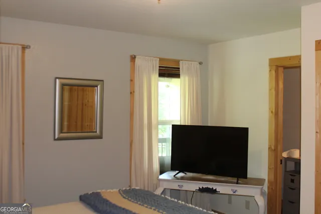 a living room with a flat screen tv and a window
