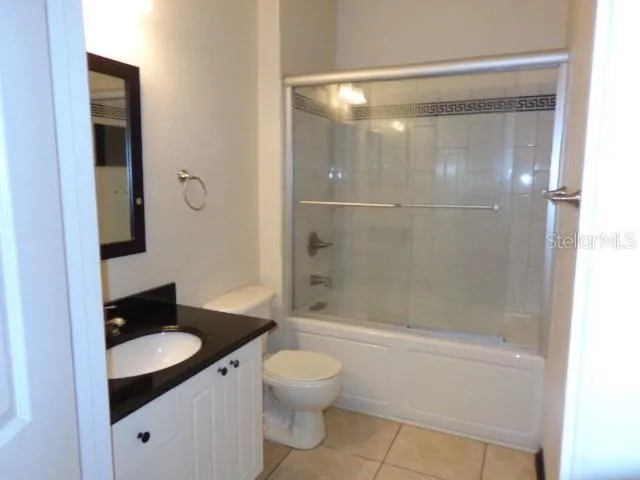 a bathroom with a granite countertop toilet a sink and a mirror