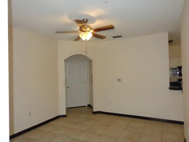a view of an empty room with a chandelier fan
