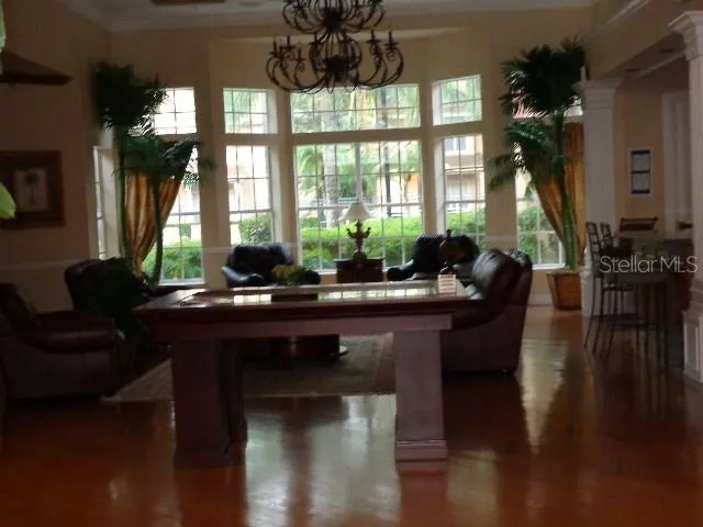 a living room with furniture large window and wooden floor