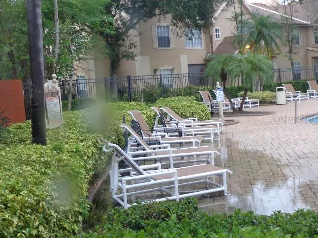 a view of a patio with table and chairs potted plants and large tree