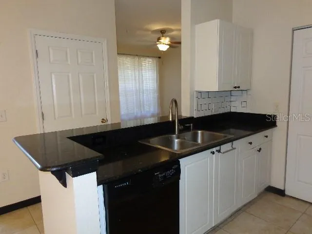 a kitchen with granite countertop a sink and cabinets
