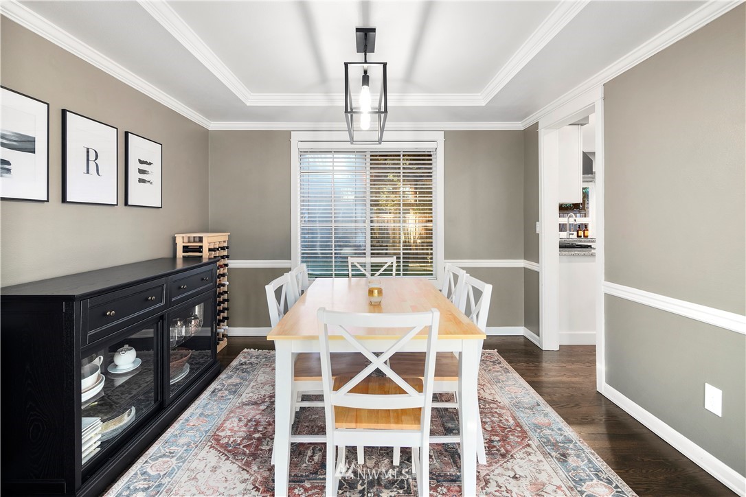 3121 210th Street Southeast Bothell, WA 98021 - Photo 9 of 40 a dining room with wooden floor a chandelier a wooden table and chairs