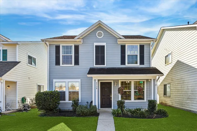 a front view of a house with a yard and green space