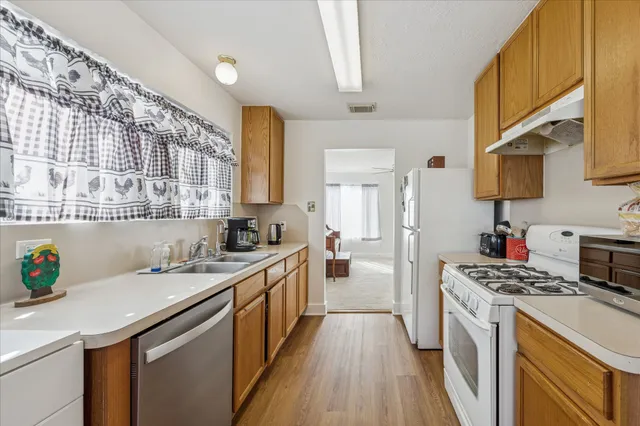 a kitchen with a sink a stove cabinets and appliances