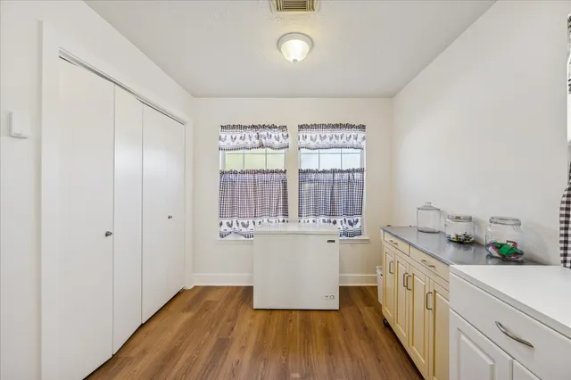 a kitchen with a sink and wooden floor