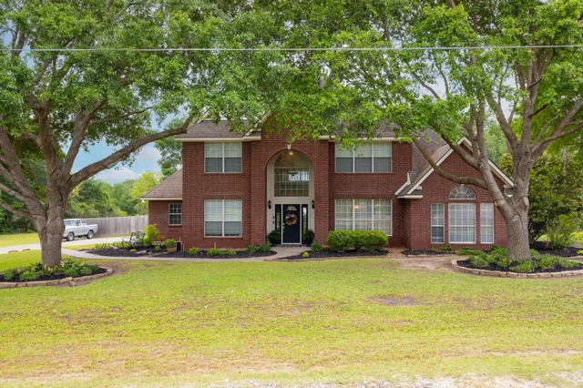 a front view of a house with a yard and trees