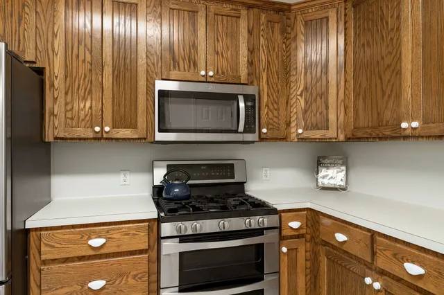 a kitchen with granite countertop wood cabinets and stainless steel appliances