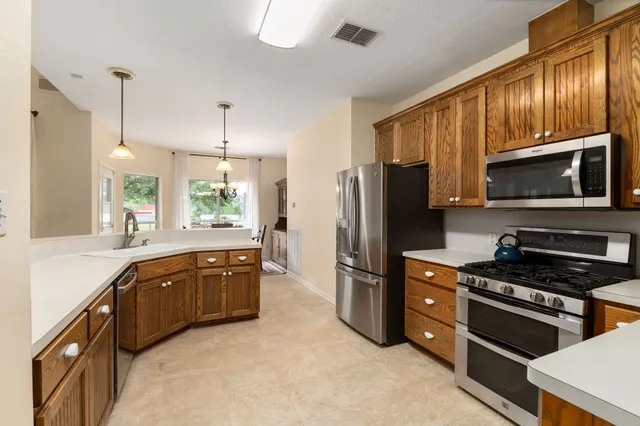 a kitchen with stainless steel appliances granite countertop a refrigerator stove microwave and sink
