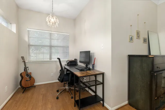 a view of a workspace with furniture and a window
