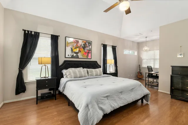 a bedroom with a bed a couch and a flat tv screen on dresser