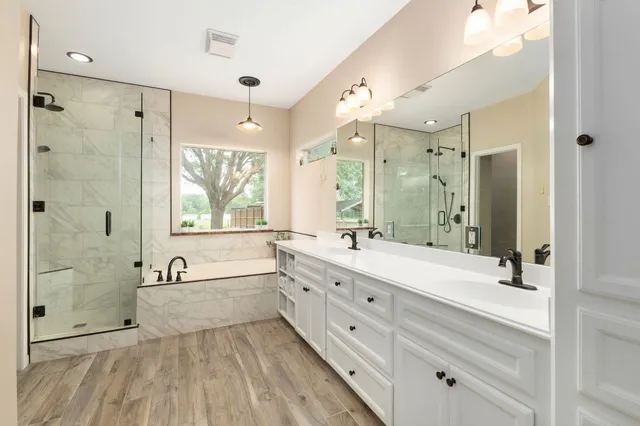 a spacious bathroom with a double vanity sink mirror double and shower