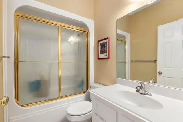 a bathroom with a bathtub shower sink vanity and toilet
