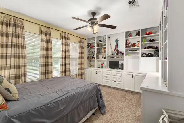 a bedroom with a bed cabinets and a window