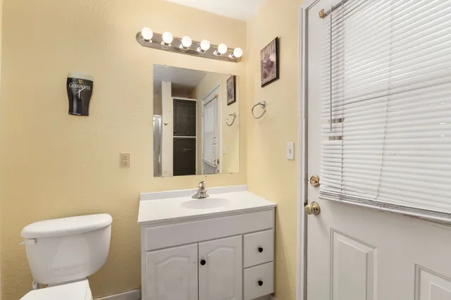a bathroom with a sink a toilet and mirror