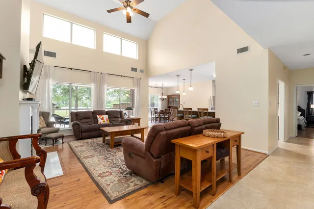 a living room with fireplace furniture and a large window