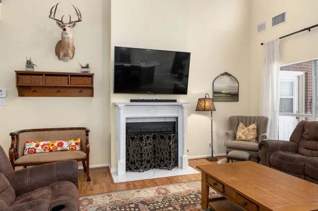 a living room with furniture a flat screen tv and a fireplace