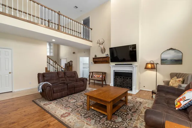 a living room with furniture a flat screen tv and a fireplace