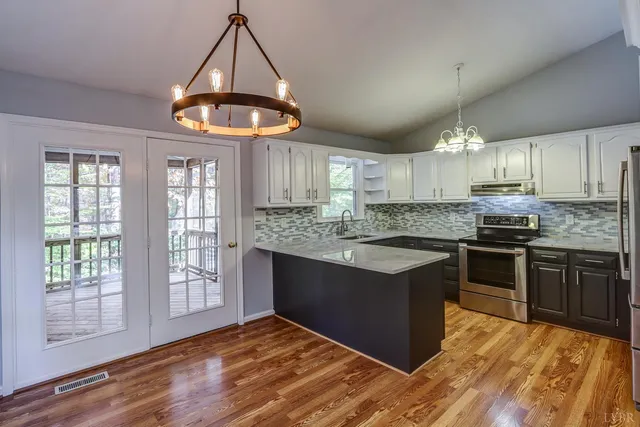 wooden floor fireplace and windows in an empty room
