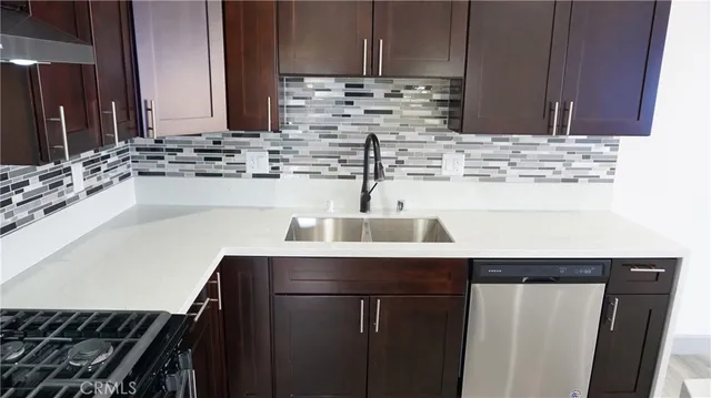 a kitchen with stainless steel appliances a sink stove and cabinets
