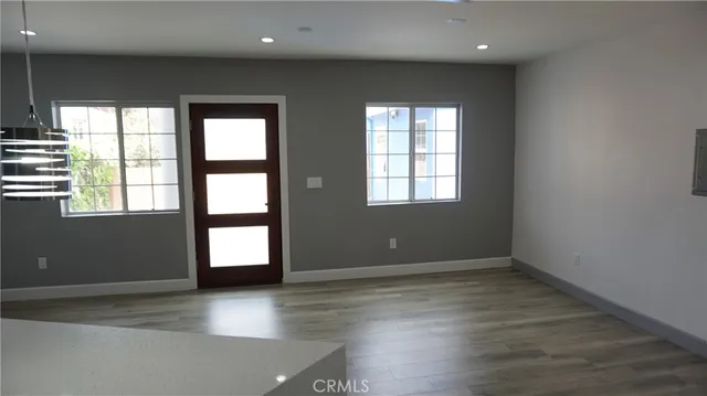 a kitchen with kitchen island granite countertop wooden cabinets and refrigerator