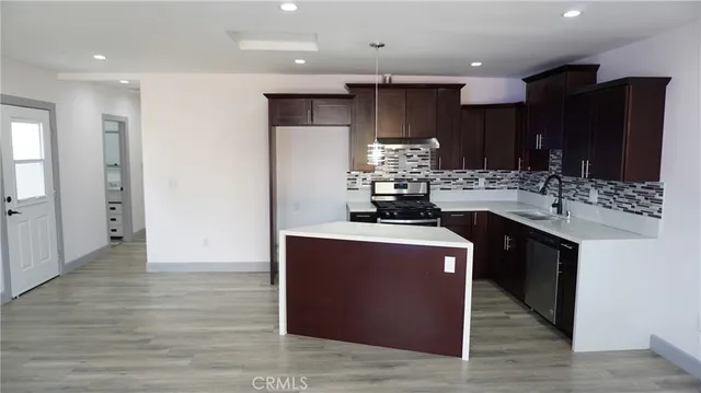 a kitchen with kitchen island a sink stainless steel appliances and cabinets