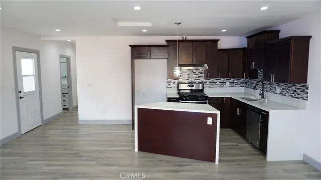 a kitchen with stainless steel appliances granite countertop a sink a stove a refrigerator and a microwave