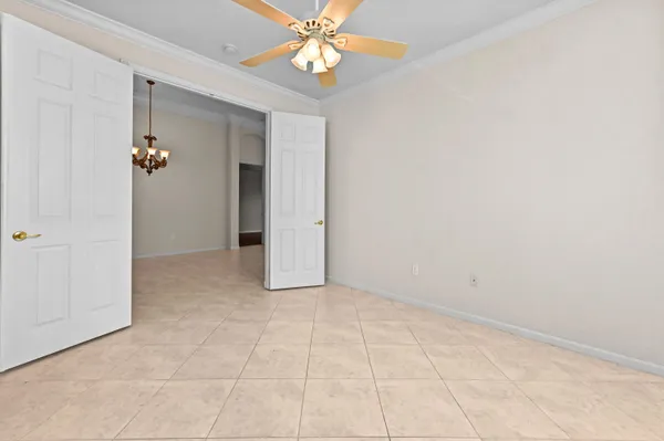 an empty room with closet and a chandelier fan