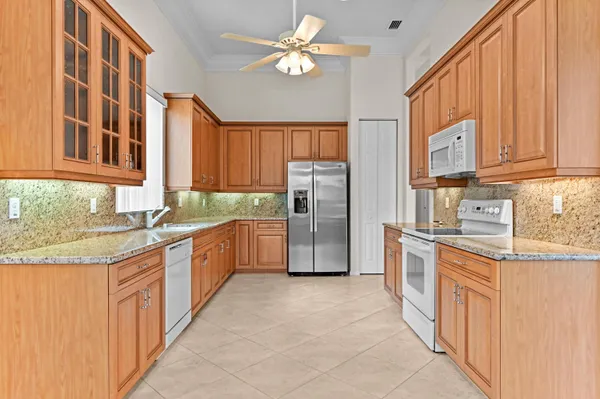 a kitchen with stainless steel appliances granite countertop a refrigerator and a sink