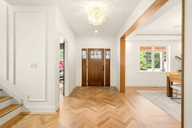 a view of a hallway with wooden floor and a chandelier