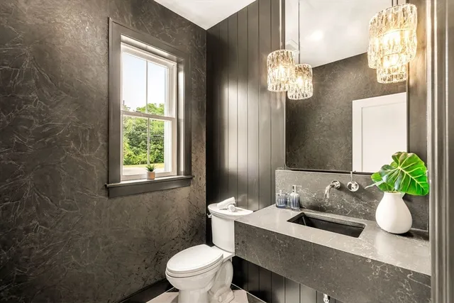 a bathroom with a sink a toilet and a mirror