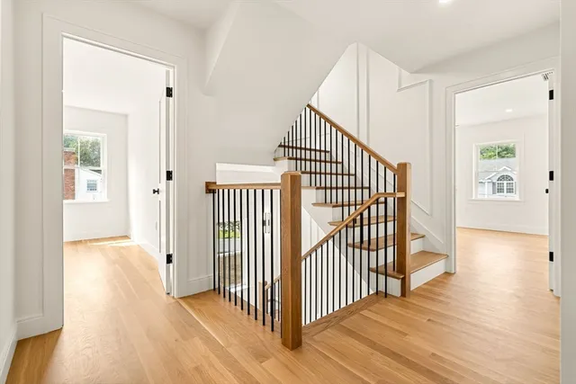 a view of a hallway with wooden floor and windows
