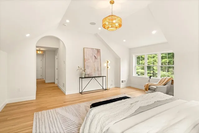 a bedroom with a bed and a chandelier