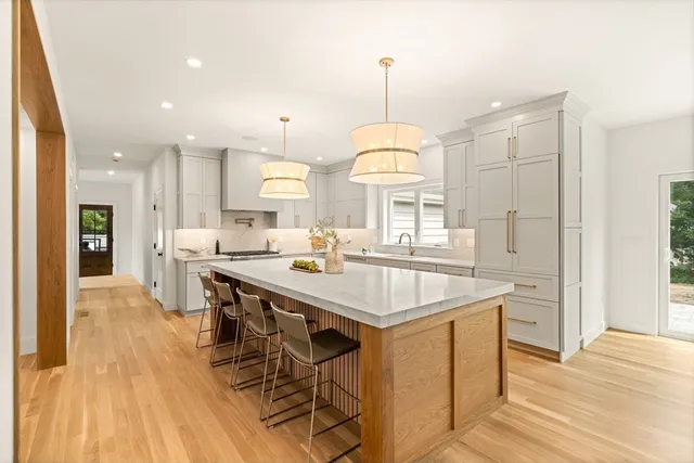 a kitchen with stainless steel appliances kitchen island a large island in the center and cabinets