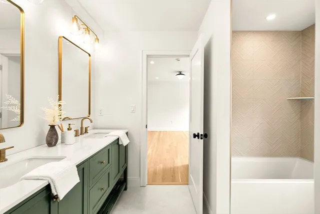 a bathroom with a double vanity sink mirror and shower