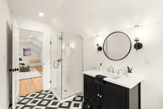 a bathroom with a sink a mirror a vanity and a shower