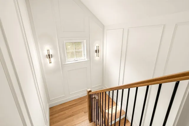 a view of a hallway with wooden floor and a window