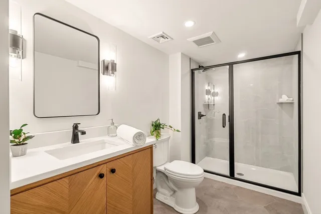a bathroom with a sink a toilet and shower