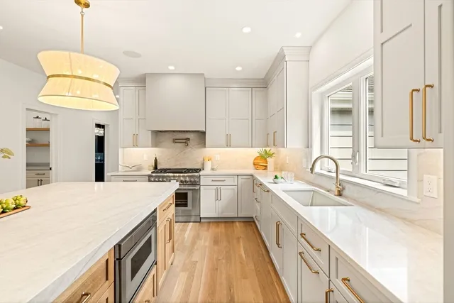 a large kitchen with kitchen island a large counter space a sink stainless steel appliances and cabinets